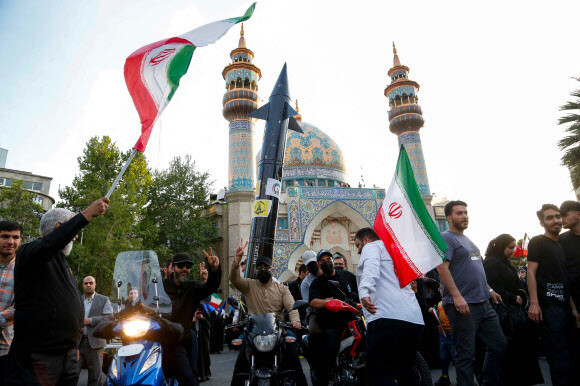 이란 시민들이 15일(현지시각) 이란 수도 테헤란 중심가인 팔레스타인 광장에서 전날 이스라엘을 향해 보복공격을 벌인 이란 정부 결정을 환영하는 퍼포먼스를 하고 있다. 테헤란/AFP 연합뉴스