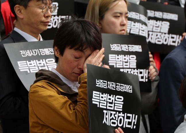 지난해 4월 26일 국회 앞에서 열린 전세사기 특별법 제정 촉구 기자회견에서 한 참석자가 눈물을 닦고 있다. 연합뉴스