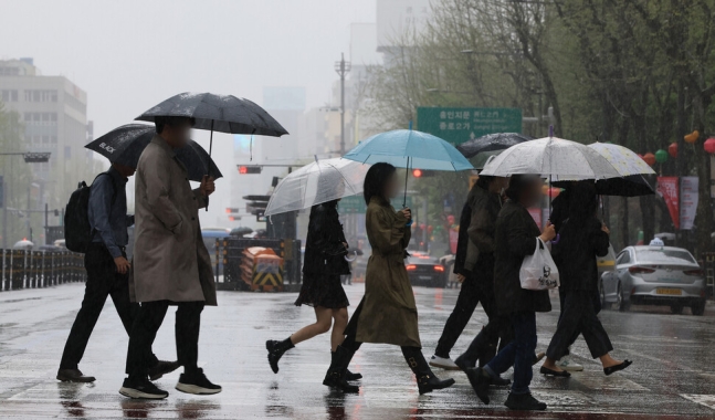 비가 내리는 서울 종로구청입구 앞 횡단보도에서 시민들이 우산을 쓰고 걸어가고 있다. 연합뉴스