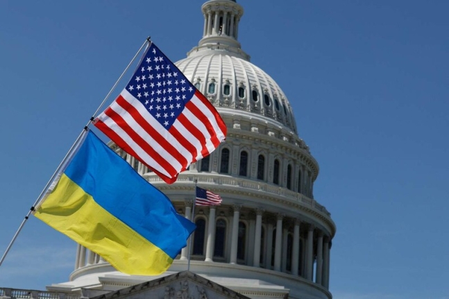 우크라이나 지원법안이 미국 의회에서 통과된 23일 워싱턴 연방의사당 앞에 활동가 한 명이 자전거에 꽂아 둔 미국 성조기와 우크라이나 깃발이 펄럭이고 있다. AFP 연합뉴스
