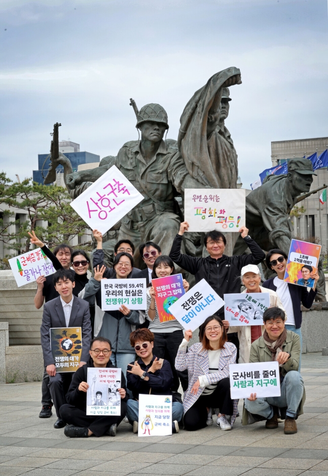 2024 세계 군축행동의 날인 지난 22일 오전 박석진 열린군대시민연대 상임활동가(뒷줄 오른쪽 둘째) 등 28개 시민사회단체 회원들이 서울 용산구 전쟁기념관 앞에서 기자회견을 마친 뒤 평화를 염원하는 손팻말들을 들어