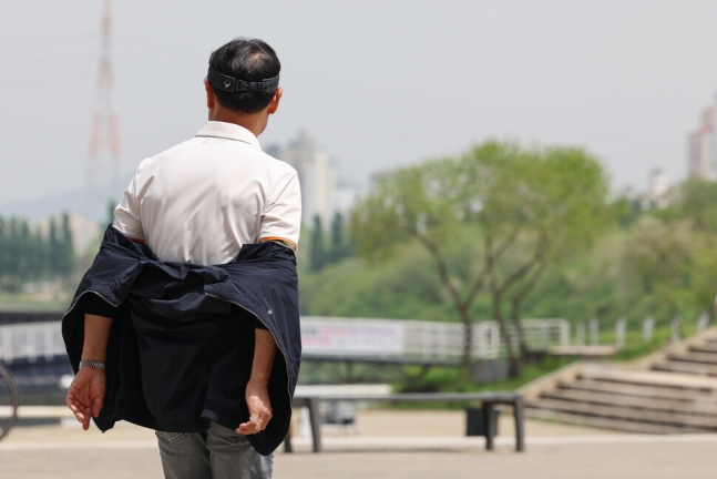 전국 대부분 지역의 낮 기온이 25도 이상으로 올라간 26일 서울 서초구 반포한강공원을 찾은 시민이 겉옷을 반만 입고 있다. 연합뉴스