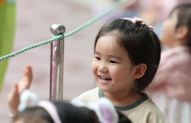 어린이날인 5일 오후 서울 송파구 롯데월드에서 한 어린이가 로티스 어드벤처 퍼레이드를 보며 밝게 웃고 있다. 백소아 기자