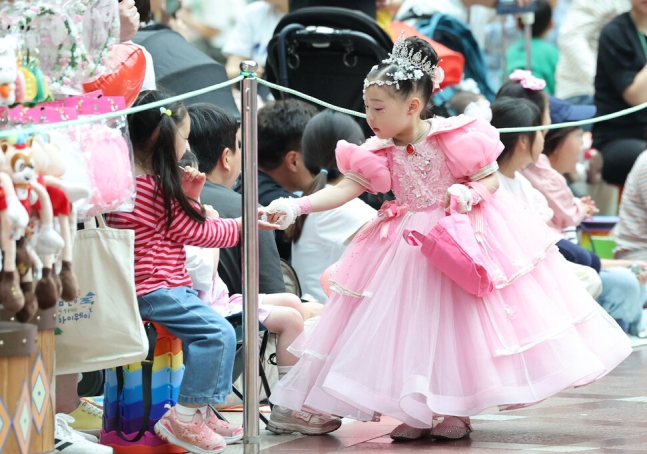 어린이날인 5일 오후 서울 송파구 롯데월드에서 로티스 어드벤처 퍼레이드에 참가한 한 어린이가 관람객들에게 간식을 나눠주고 있다. 백소아 기자