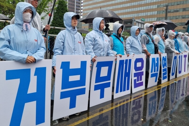 11일 오후 열린 ‘윤석열 정권 2년, 거부권 거부대회’에서 시민들이 피켓을 들고 서 있다. 김가윤 기자