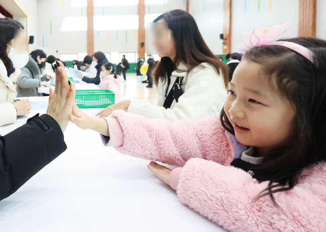 지난해 12월26일 오후 경기도 수원시 영통구 영덕초등학교에서 열린 신입생 예비 소집에서 예비 초등학생이 선생님과 인사하고 있다.<BR> 연합뉴스