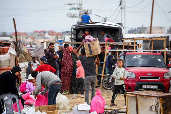 팔레스타인 주민들이 13일(현지시각) 라파흐에 예고된 폭격을 피해 급한 짐들을 챙겨 피란을 떠나고 있다. 라파흐/AFP 연합뉴스