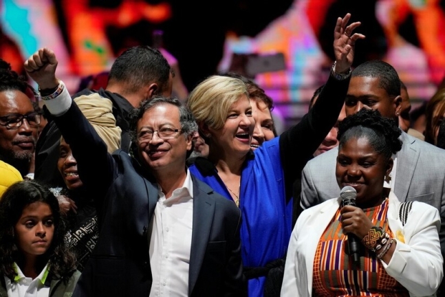 구스타보 페트로 콜롬비아 대통령이 2022년 6월19일 밤(현지시각) 수도 보고타에서 대선 결선 승리 뒤 부인 베로니카 알코세르(가운데), 프란시아 마르케스 부통령 당선자(오른쪽)와 함께 손을 흔들고 있다. AP 연