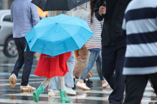 지난달 27일 오후 서울 광화문네거리에서 어린이가 우산을 쓰고 횡단보도를 건너고 있다. 연합뉴스