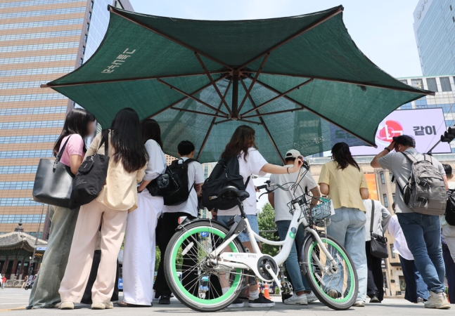 9일 서울 종로구 광화문 네거리에 설치된 그늘막 아래 시민들이 모여있다. 연합뉴스