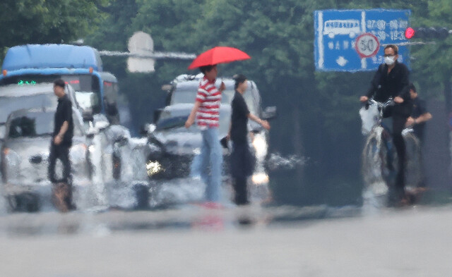더위가 계속된 14일 대구 중구 공평네거리에서 시민들이 아지랑이가 피어오르는 도로 위를 지나가고 있다. 연합뉴스