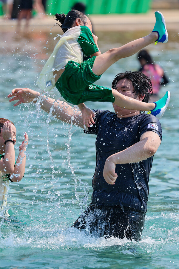 서울 한낮 기온이 35.8도까지 오르며 더운 날씨를 보인 지난 19일 오후 개장 행사가 열린 서울 송파구 잠실한강공원 수영장에서 시민들과 어린이들이 물놀이를 즐기고 있다. 연합뉴스