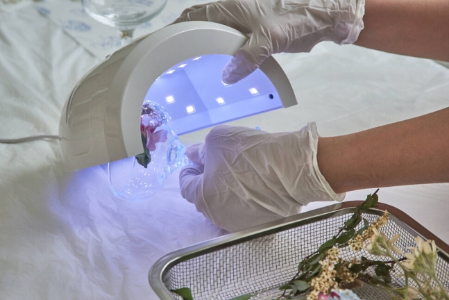 지난 14일 서울 강서구 레진공방 클라우드봉봉 1일 강좌에서 수강생이 부케를 활용한 레진아트 향초 거치대를 유브이(UV) 램프에 넣어 굽고 있다. 스튜디오 어댑터 경지은