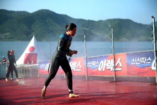 정인선 기자가 ‘2024 아이언맨 70.3 고성’ 대회에서 수영 경기를 마친 뒤 바꿈터로 달려가고 있다. 신현두 제공