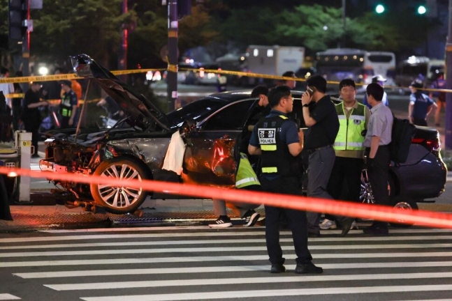 1일 밤 대형 교통사고가 발생한 서울 시청역 인근 교차로에서 경찰이 완전히 파괴된 차량 한 대 주변을 통제하고 있다. 연합뉴스
