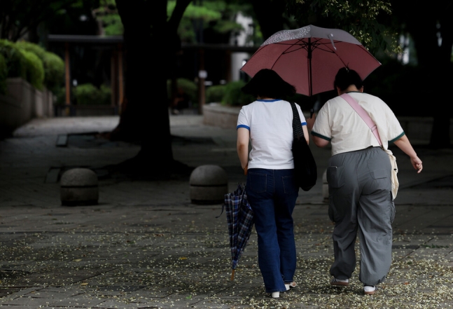 지난달 30일 오전 서울 종로구 청계천 인근에서 시민들이 우산을 쓰고 이동하고 있다. 연합뉴스