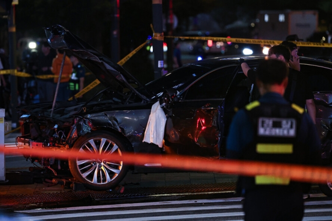 1일 대형 교통사고가 발생한 서울 시청역 인근 교차로에서 경찰이 완전히 파괴된 차량 한 대 주변을 통제하고 있다. 연합뉴스