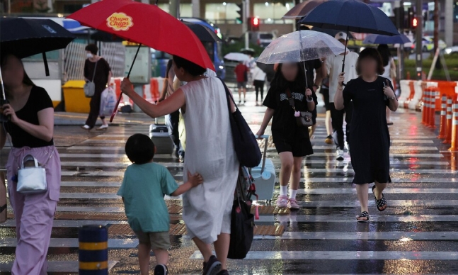서울 일부 지역에 폭우가 내린 지난해 7월30일 오후 서울역 인근에서 시민들이 우산을 쓴 채 횡단보도를 건너고 있다. 연합뉴스