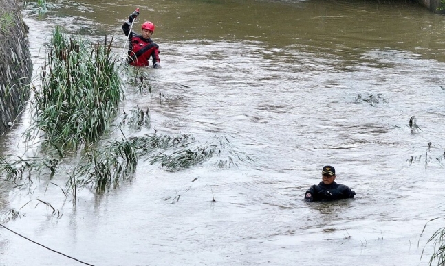 9일 오후 경북 경산시 진량읍 평사리 소하천에서 소방구조대가 폭우에 실종된 여성을 수색하고 있다. 연합뉴스