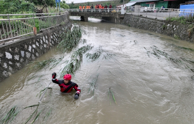 9일 오후 경북 경산에서 소방구조대가 폭우에 실종된 여성을 수색하고 있다. 연합뉴스