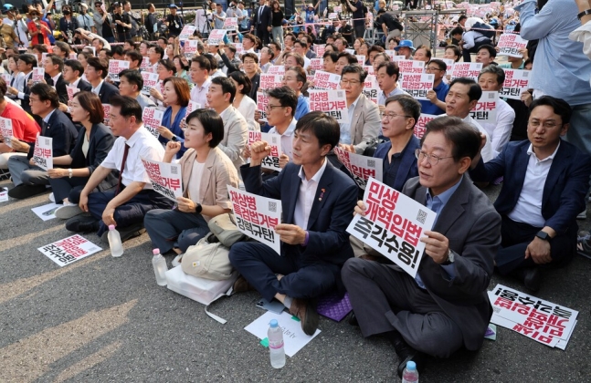 이재명 더불어민주당 전 대표가 13일 광화문광장 인근에서 열린 채상병 특검법 거부권 규탄 범국민대회에 참석하고 있다. 이 전 대표는 주최 쪽이 앞줄 가운데 자리로 안내했지만, 가장자리에 앉았다. 연합뉴스