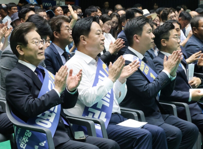 더불어민주당 새 지도부 선출을 위한 전당대회를 앞두고 20일 제주 한라체육관에서 열린 합동연설회에서 이재명·김두관·김지수 대표 후보(왼쪽부터)가 나란히 앉아 손뼉을 치고 있다. 연합뉴스