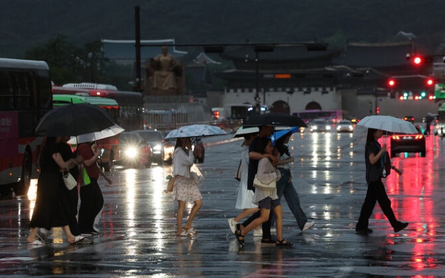 Citizens crossing the crosswalk with umbrellas at Gwanghwamun Square in Seoul while rain falls on the afternoon of the 20th. Yonhap News