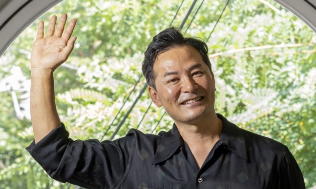‘소통 명강사’ 김창옥씨가 손을 들어 흔들며 활짝 웃고 있다.<BR> 소통 관련 인터뷰는 지난 3일 서울 강남 한 스튜디오에서 진행됐다.<BR> 김진수 선임기자 jsk@hani.co.kr