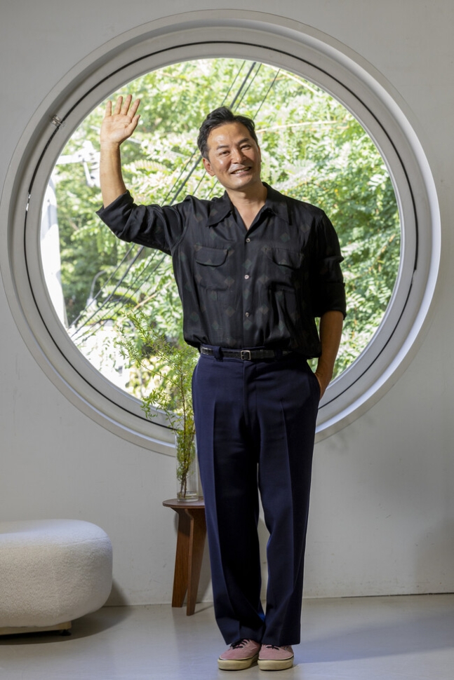 ‘소통 명강사’ 김창옥씨가 손을 들어 흔들며 활짝 웃고 있다.<BR> 소통 관련 인터뷰는 지난 3일 서울 강남 한 스튜디오에서 진행됐다.<BR> 김진수 선임기자 jsk@hani.co.kr