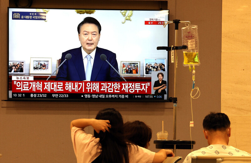 지난 8월29일 오전 윤석열 대통령의 ‘국정브리핑 및 기자회견’이 대형 화면을 통해 중계되고 있는 서울의 한 대학병원 로비에서 환자와 보호자가 ‘의료개혁’ 관련 방송 내용을 지켜보고 있다. 김태형 기자 xogud55