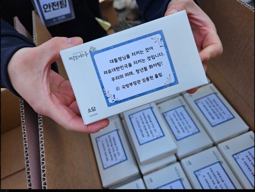 29일 서울 신촌역 일대에서 ‘탄핵을 반대하는 대한민국 청년’등 주최로 열린 ‘자유 토크쇼’에서 김용현 전 국방부 장관 쪽이 참가자들에게 ‘용현이형 응원떡’을 돌렸다. X(엑스) 갈무리