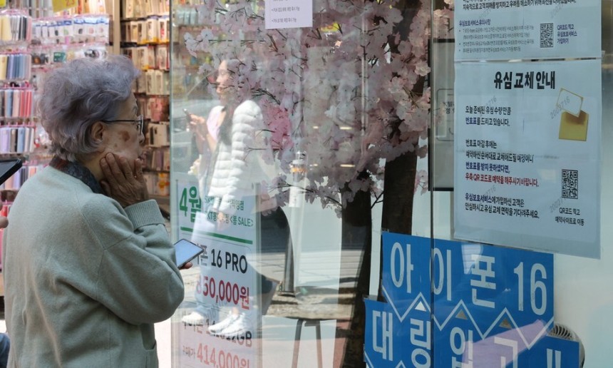 가입자 유심(USIM) 정보를 탈취당한 SK텔레콤이 유심 무료 교체 서비스를 시작한 지 이틀째인 29일 서울 시내 한 SKT 대리점에 시민들이 유심교체 안내판을 보고 있다. 정용일 선임기자 yongil@hani.co