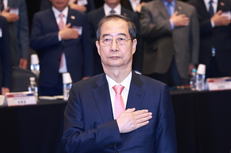 한덕수 대통령 권한대행 국무총리가 30일 서울 여의도 중소기업중앙회에서 열린 ‘중소기업 규제혁신 현장 소통 간담회’에서 국기에 경례하고 있다. 연합뉴스