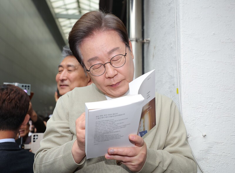 이재명 더불어민주당 대통령 후보가 ‘골목골목 경청투어: 국토종주편’에 나선 6일 충북 옥천군 옥천공설시장에서 한 지지자가 가져온 이 후보의 저서 ‘결국 국민이 합니다’에 사인을 하고 있다. 연합뉴스