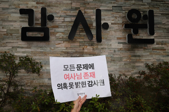 대통령실·대통령 관저 이전 불법 의혹 국민감사 결과가 나온 12일 오후 참여연대 관계자들이 서울 종로구 감사원 앞에서 감사 결과를 규탄하는 기자회견을 마친 뒤 감사원 정문 담벼락에 손팻말을 가까이 들고 사진을 찍고 
