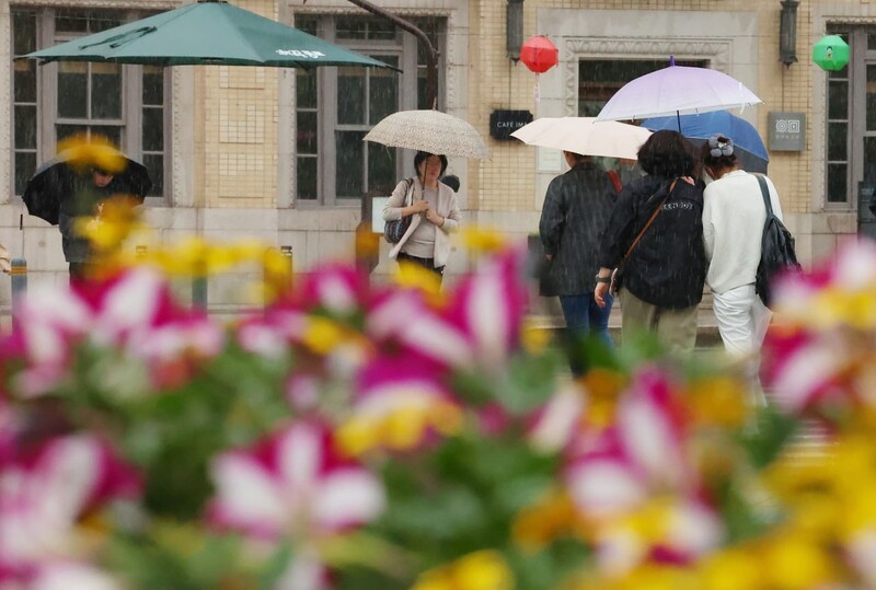 전국적으로 비가 내린 지난 1일 서울 종로구 세종로사거리에 심어진 화단 뒤로 우산을 쓴 시민들이 길을 지나고 있다. 연합뉴스