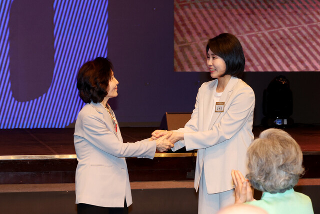 김문수 국민의힘 대통령 후보의 부인 설난영씨(왼쪽)와 이재명 더불어민주당 대통령 후보의 부인 김혜경씨가 12일 서울 중구 신라호텔에서 열린 중앙신도회 창립 70주년 기념식에서 손을 맞잡고 있다. 연합뉴스