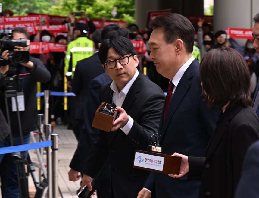 윤석열 전 대통령이 19일 서울 서초구 중앙지방법원에서 열린 내란 우두머리 혐의, 직권남용 권리행사방해 혐의 사건 4차 공판에 출석, 취재진의 질문을 받으며 이동하고 있다. 사진공동취재단