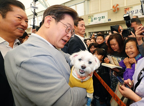 더불어민주당 이재명 대선 후보가 지난 11일 전남 강진군 강진읍 강진오감통시장을 찾아 한 지지자의 반려견을 품에 안고 인사를 하고 있다. 연합뉴스