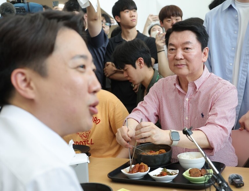 국민의힘 안철수 의원이 21일 경기 성남시 가천대학교 글로벌캠퍼스에서 열린 ‘학식 먹자 이준석\' 행사에 참석한 가운데 학생들과 대화를 나누는 개혁신당 이준석 대선 후보를 바라보고 있다. 연합뉴스