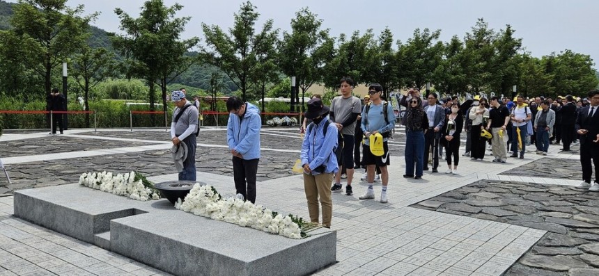 참배객들이 노무현 전 대통령 묘역 앞에 줄을 서서 헌화하고 있다.