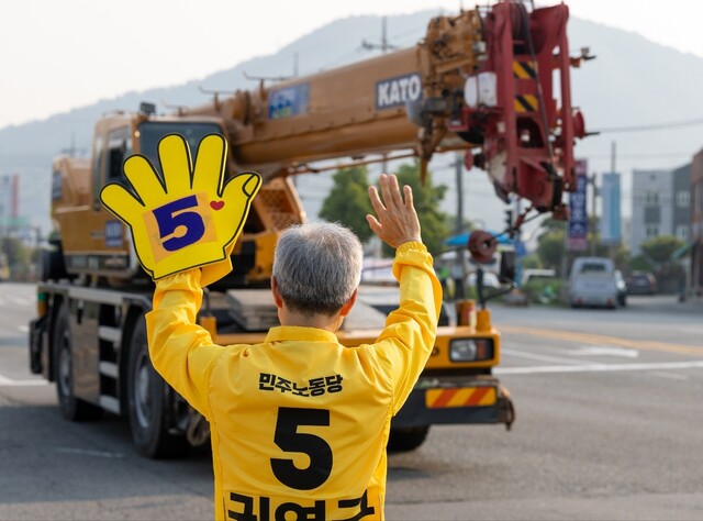권영국 민주노동당 대통령 후보가 29일 아침 전남 여수 석창사거리에서 차량을 향해 손을 흔들고 있다. 민주노동당 제공