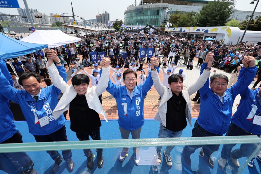 이재명 더불어민주당 대통령 후보가 열세 지역으로 분류되는 강원과 충북 지역의 표심 공략에 나선 30일 춘천시 춘천역광장에서 열린 집중유세에서 찬조연설자들과 함께 손을 맞잡고 기념 촬영하고 있다. 연합뉴스