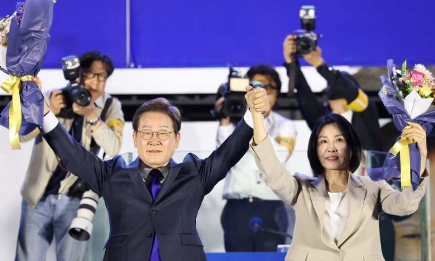 이재명 대통령 당선자와 김혜경 여사가 4일 오전 서울 여의도 국회 앞에서 열린 국민 개표방송 행사에서 꽃다발을 받은 뒤 시민들을 향해 인사하고 있다. 공동취재사진
