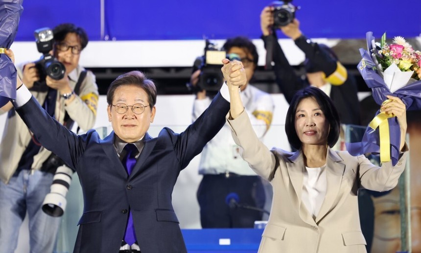 이재명 대통령 당선자와 김혜경 여사가 4일 오전 서울 여의도 국회 앞에서 열린 국민 개표방송 행사에서 꽃다발을 받은 뒤 시민들을 향해 인사하고 있다. 공동취재사진