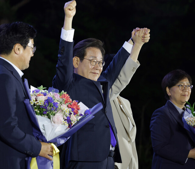 이재명 더불어민주당 후보가 제21대 대통령 당선이 확실시된 4일 오전 1시20분께 서울 여의도 국회 인근에서 당 주최로 열린 국민개표방송 행사에 참석해 김혜경 여사와 함께 시민들을 향해 두 팔을 들어 인사하고 있다.
