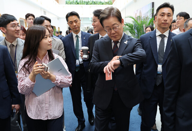 이재명 대통령이 10일 서울 용산 대통령실 청사에서 시계를 보며 이동하고 있다. 이 대통령은 이날 직원 식당에서 참모들과 점심식사를 한 뒤 마주친 출입기자와 셀카를 찍기도 했다. 연합뉴스