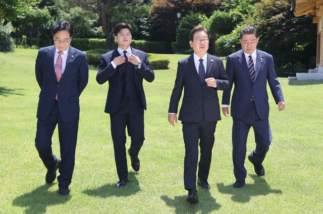 이재명 대통령이 22일 서울 한남동 관저에서 열린 여야 지도부 오찬 회동에서 기념 촬영을 마친 뒤 자리로 향하고 있다. 왼쪽부터 국민의힘 송언석 원내대표, 김용태 비상대책위원장, 이 대통령, 더불어민주당 김병기 당대