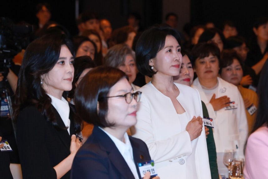 이재명 대통령의 배우자 김혜경 여사가 1일 서울 중구 신라호텔 다이너스티홀에서 열린 제4회 여성기업주간 개막식에 참석해 국기에 경례하고 있다. 왼쪽은 이부진 호텔신라 사장. (서울=연합뉴스)