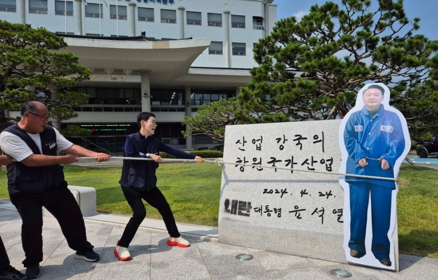 윤석열 전 대통령 친필 휘호 표지석을 훼손한 혐의로 민주노총 경남본부 소속 조합원이 검찰에 송치되자, 지역 노동계가 8일 경남 창원시 성산구 한국산업단지공단 경남지역본부 앞마당에 설치된 이 표지석을 밧줄로 묶고 잡아